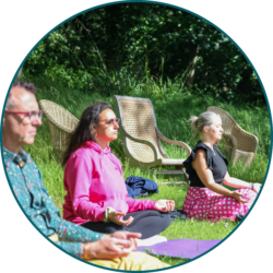 Employees participating in an outdoor mindfulness and wellbeing session in a garden setting.