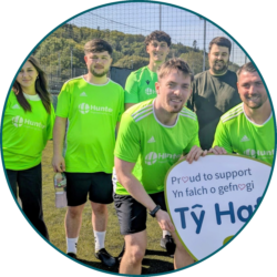 Employees wearing branded football shirts at a charity sports event supporting a local organisation.